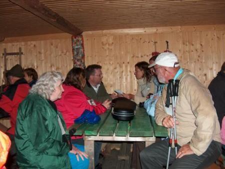 People gather in the hut behind the Dedication site