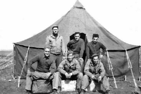 We are in Africa and have just received our first pyramidal tent and moved out of pup tents.  I am the one on the lower right.  Above me is Tony Guardabascio. Center upper is Nick Romanchuk. Center first row I believe is Dave Slayton.